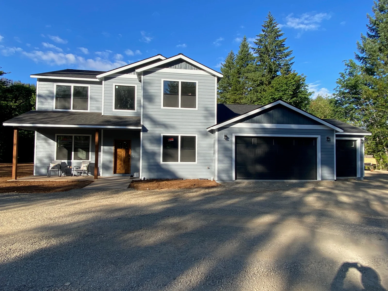 Two-story home with horizontal fiber cement siding, white trim, and covered porch with cedar posts