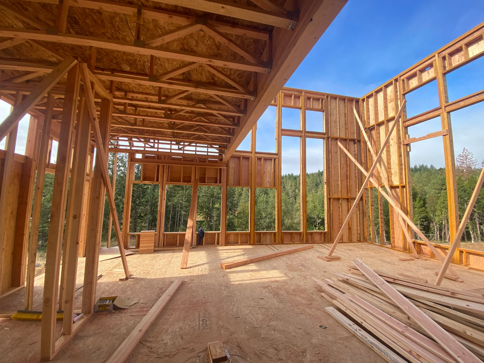Timber frame construction with exposed beams, trusses, and large window openings