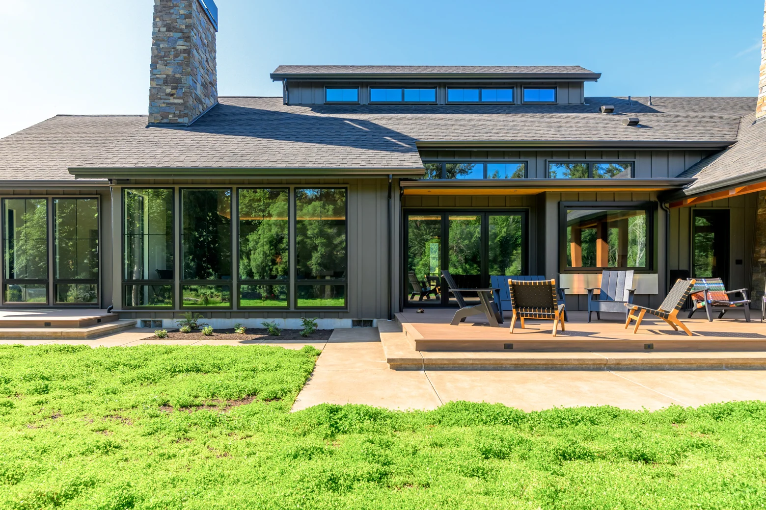 Charcoal fiber cement siding with black-framed windows and glass doors on modern home exterior